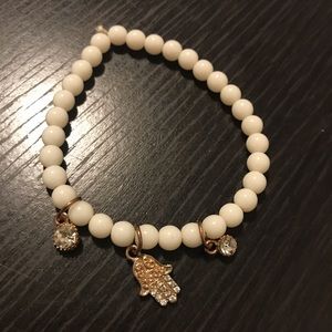Stretchy white bracelet with hand charm